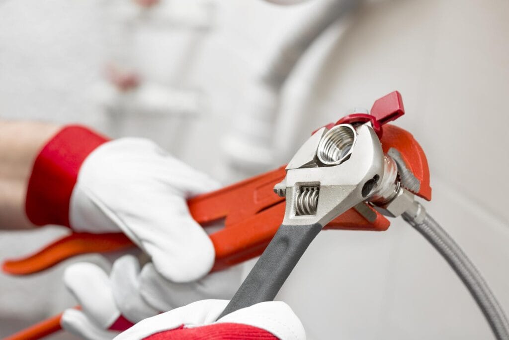 Plumber holding pipe wrenches for an emergency repair in Haines City