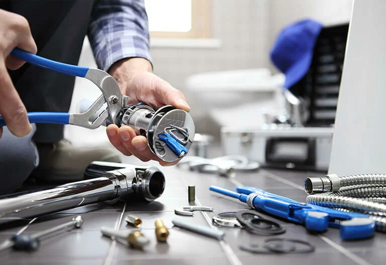 Technician repairing a plumbing fixture with professional tools in Haines City