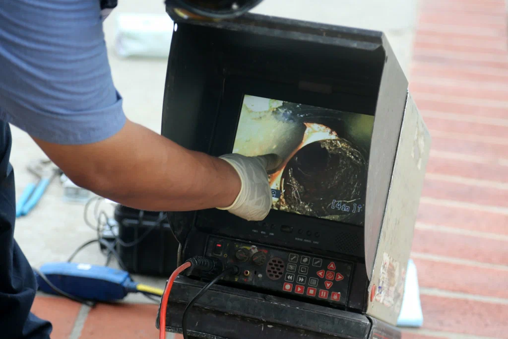 Technician viewing a drain inspection camera in Haines City