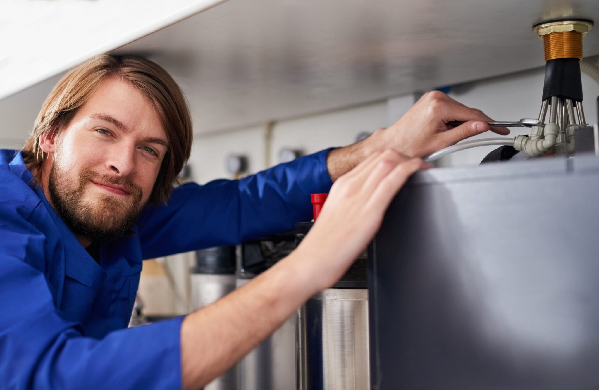 Technician servicing a residential water heater tank in Haines City